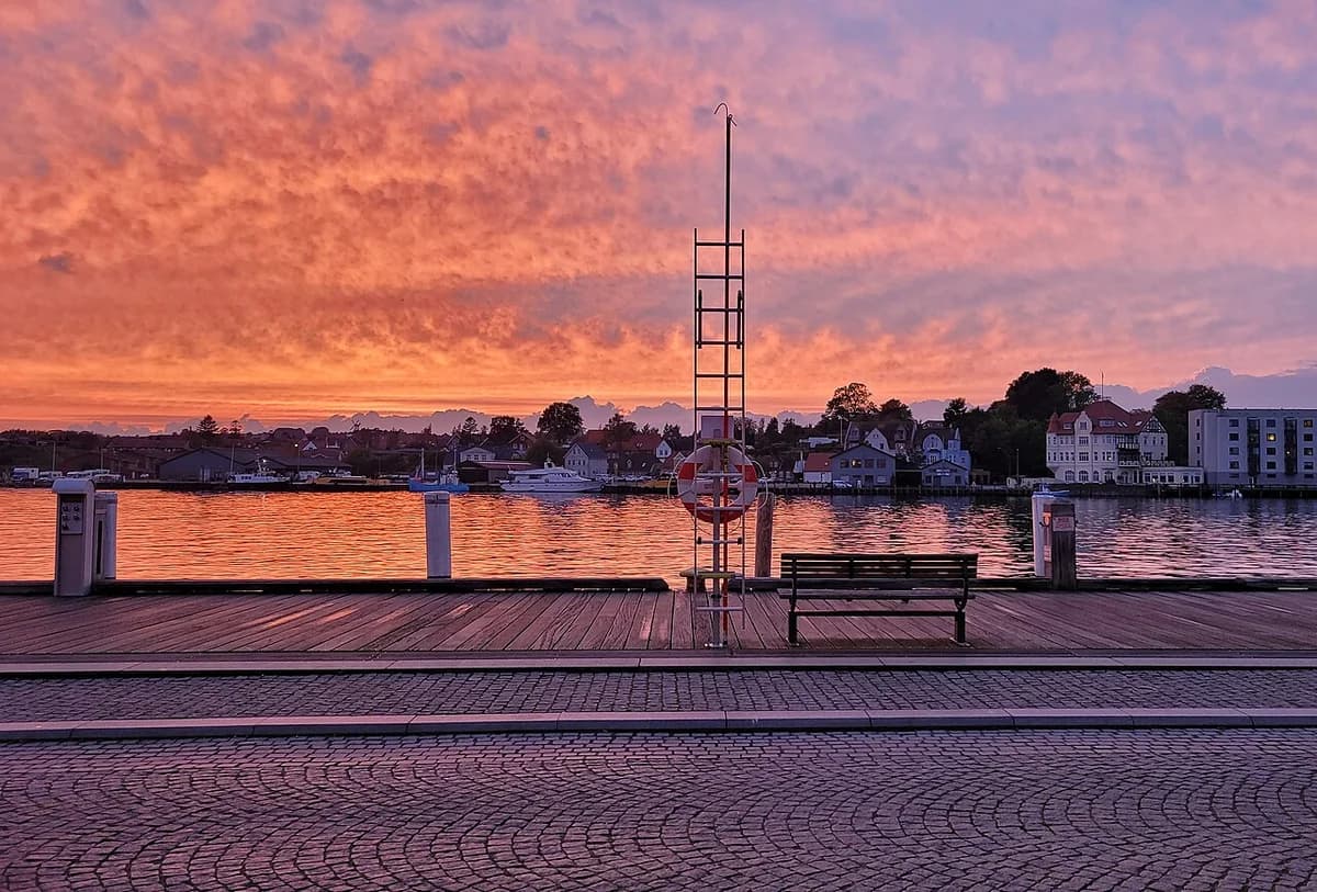 Sunset over Sønderborg harbor with colorful clouds and waterfront promenade