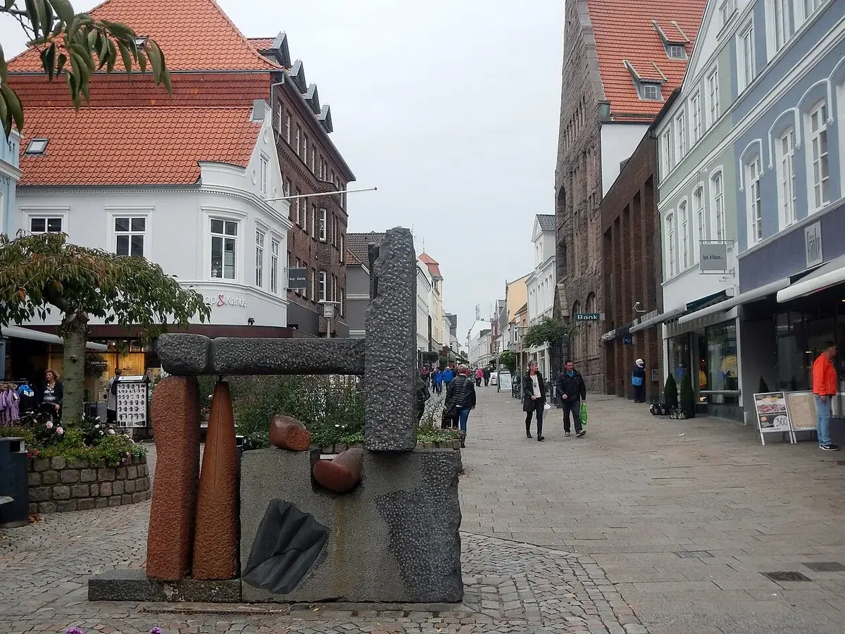 Street scene on a shopping street in Sønderborg with pedestrians and historic buildings.