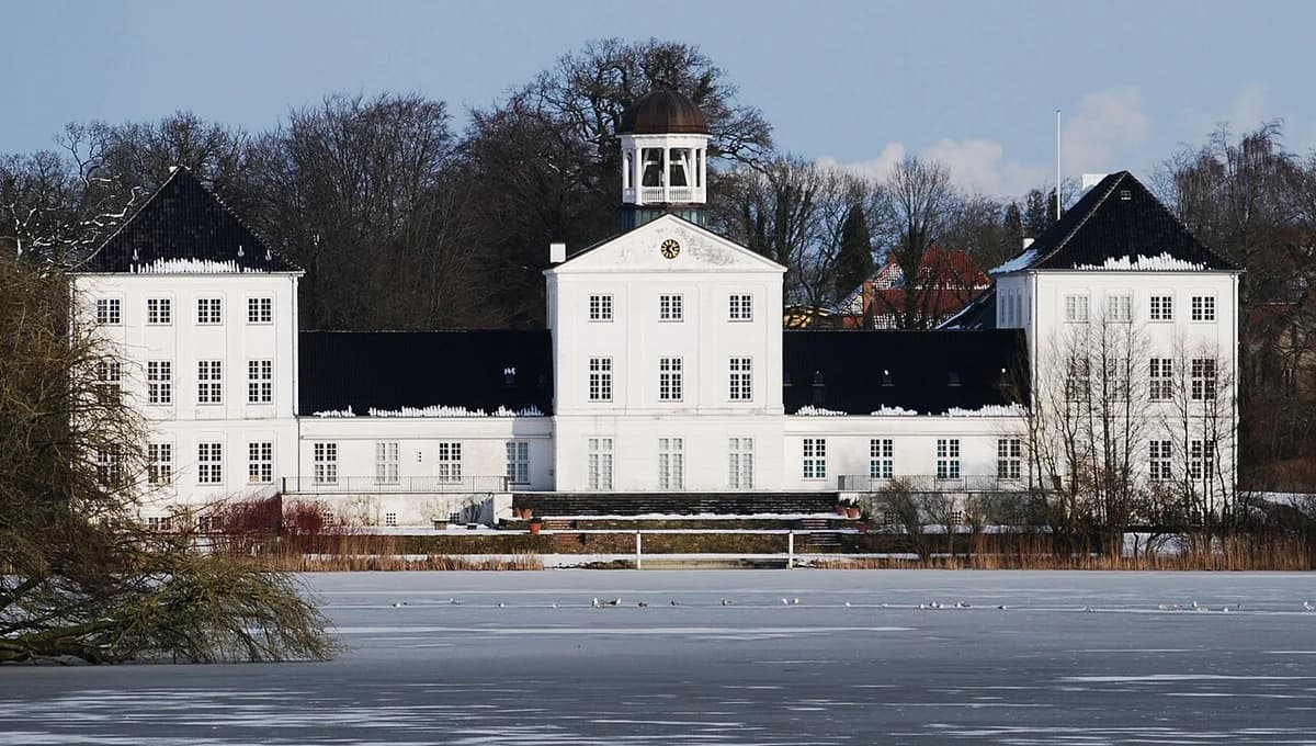 Gråsten Palace with frozen lake in front and winter trees behind